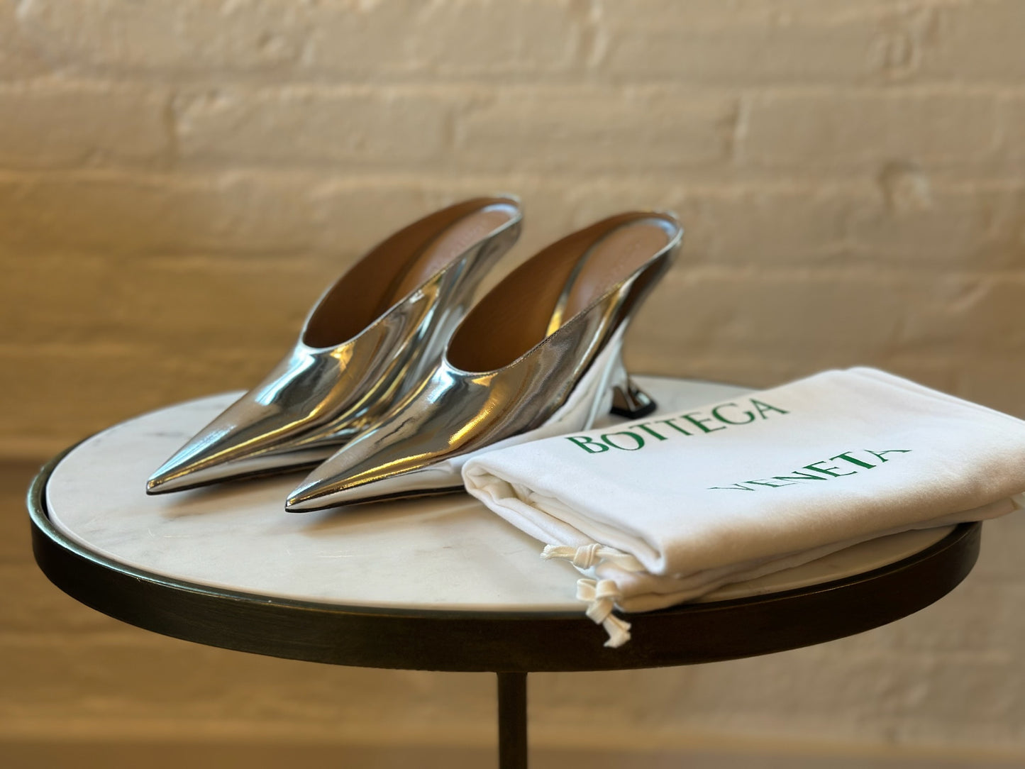 Bottega Veneta Silver Rocket Mules Sitting on Stool Next to Dustbag