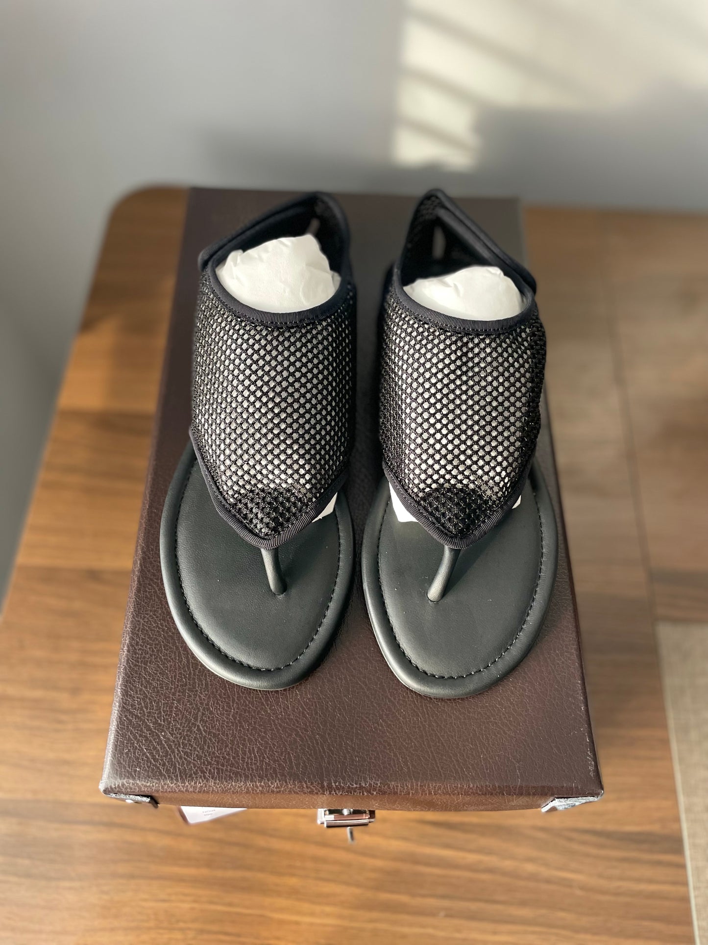 Alaia black mesh thong flat sandals top view on box