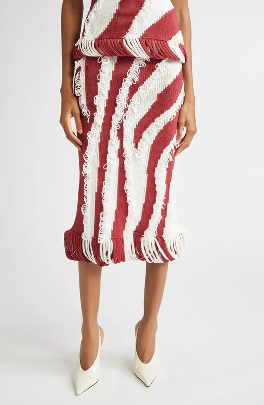 Model wearing Diotima Roaring Knit skirt in red + white with white pumps