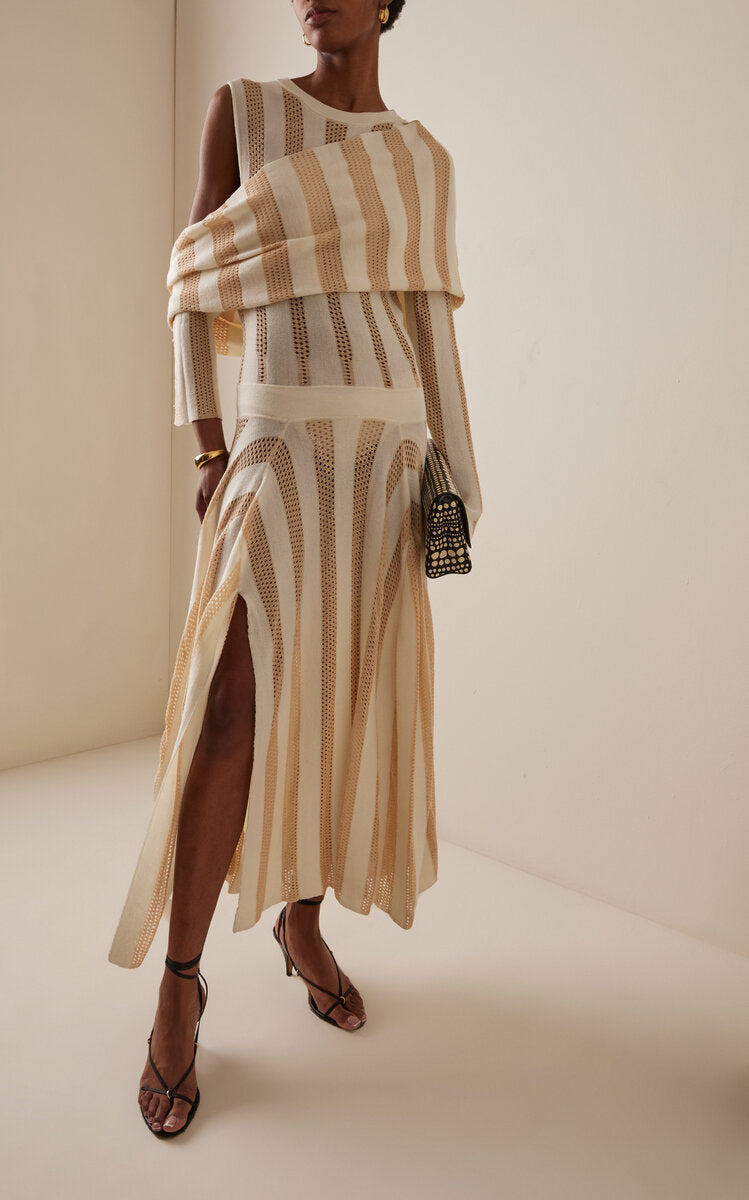 Model wearing a Diotima striped maxi dress with a high slit skirt on a plain background