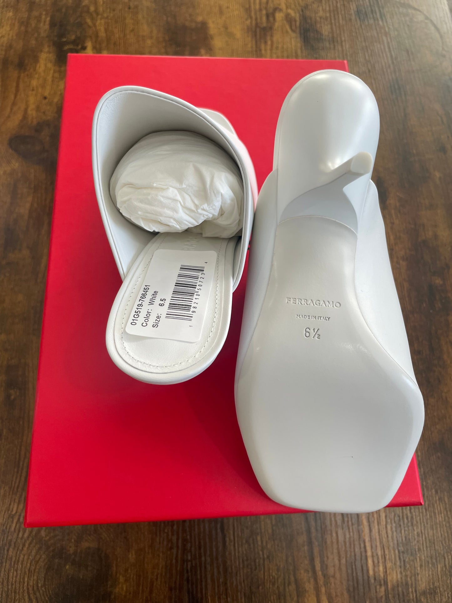 View of white square toe Ferragamo shoe showing sole and footbed on red shoebox 